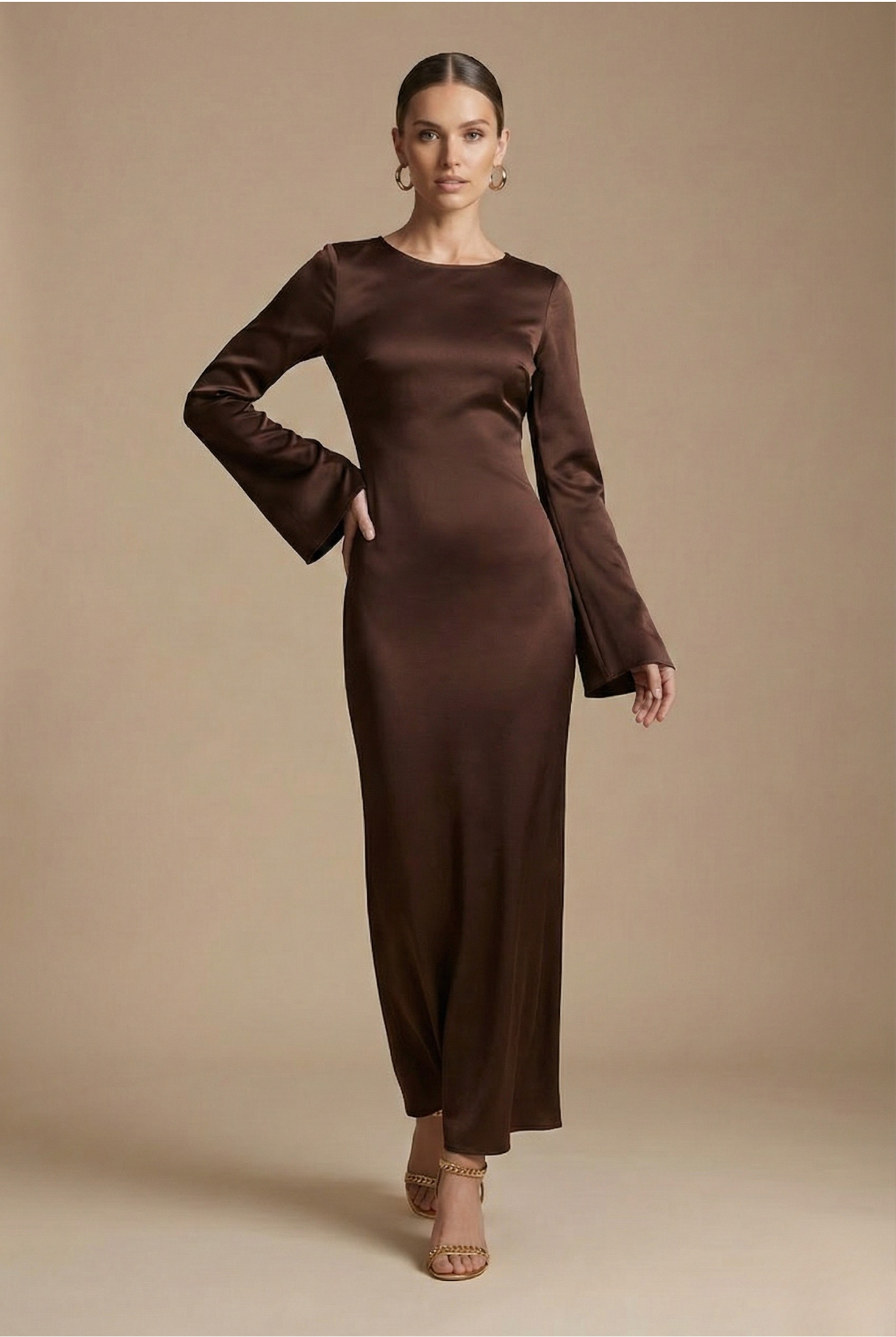 Brown satin maxi dress with long sleeves and round neckline, fitted column style
